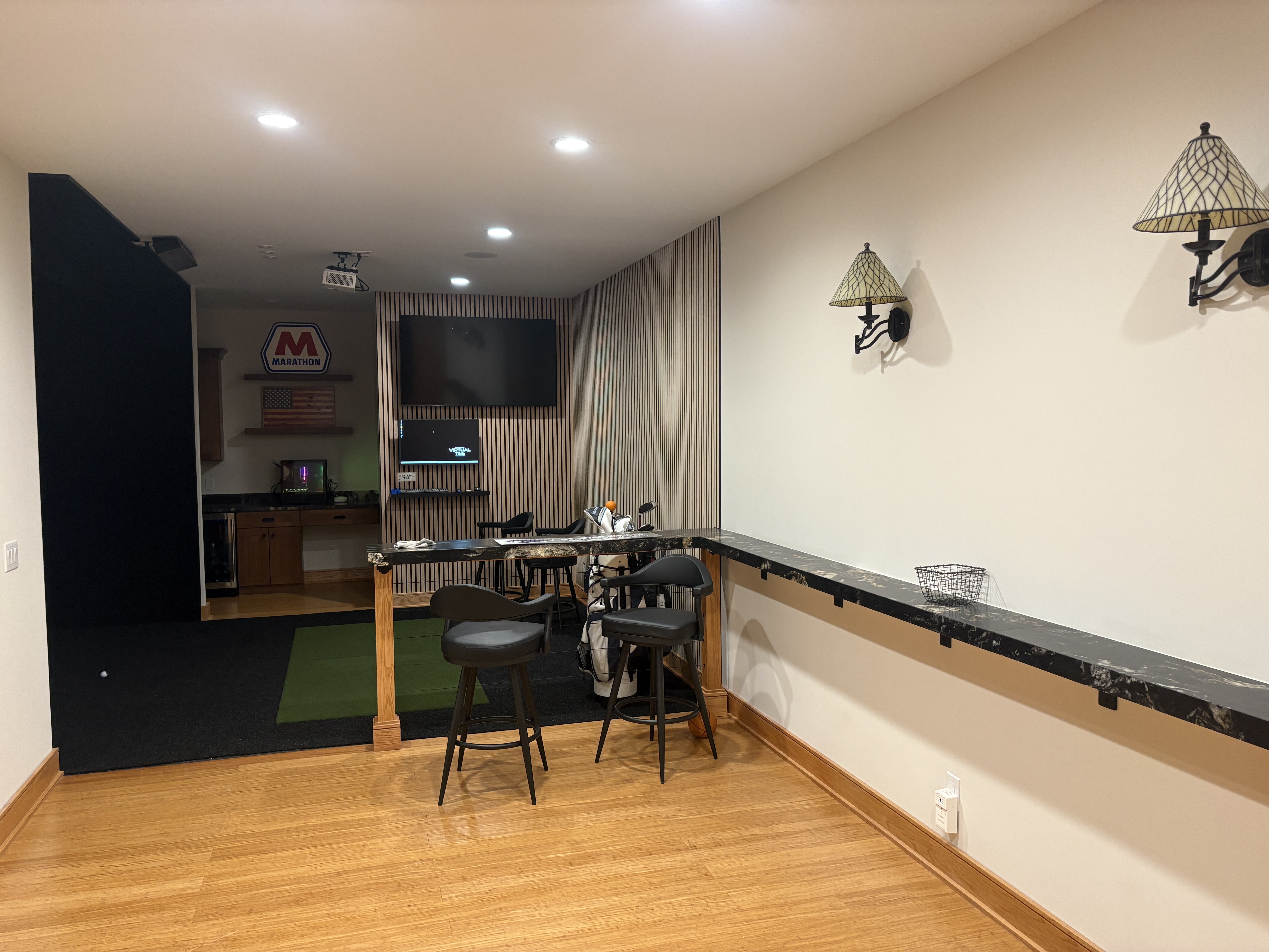 Golfers Paradise basement — full view with simulator bay, granite bar, slatted accent wall, and wet bar by Luxe Built Louisville KY